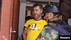 FILE - Drug lord Jarvis Chimenez Pavao, alias "Pavao," is escorted to his cell in Asuncion after being arrested in Concepcion, Paraguay, Dec. 27, 2009.