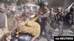 Police use pepper spray against protesters in Portland, Oregon, May 31, 2020, in this still image taken from video obtained by Reuters.