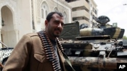 A rebel fighter beside a captured government tank in Misrata, Libya, April 22, 2011