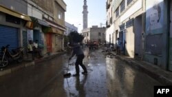 Des personnes en train de nettoyer la rue suite à une crue mortelle dans la ville de Dar Chaabane, en Tunisie, le 23 septembre 2018.