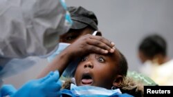 A young girl reacts as a medical worker takes a swab during mass tasting in an effort to fight against the spread of the coronavirus disease (COVID-19) in the Kawangware neighborhood of Nairobi, Kenya, May 2, 2020.