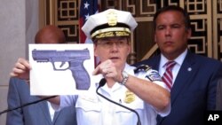 Columbus, Ohio, Police Chief Kim Jacobs holds up a photo showing the type of BB gun that police say a 13-year-old boy pulled from his waistband just before he was shot and killed by police investigating an armed robbery report, Sept. 15, 2016. Police say the boy, Tyre King, died at a hospital after the Wednesday evening shooting.