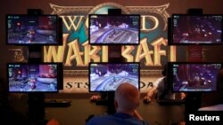 Para pengunjung bermain ''World of Warcraft'' dalam sebuah pameran di acara Gamescom 2012 di Cologne.