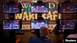 Para pengunjung bermain ''World of Warcraft'' di stand pameran Gamescom 2012 di Cologne.