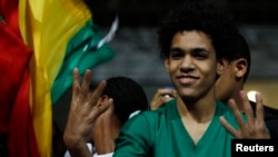 A fan gestures with a Rabaa sign after the 2014 World Cup qualifying second leg playoff soccer match between Ghana and Egypt in Cairo, Nov. 19, 2013. 