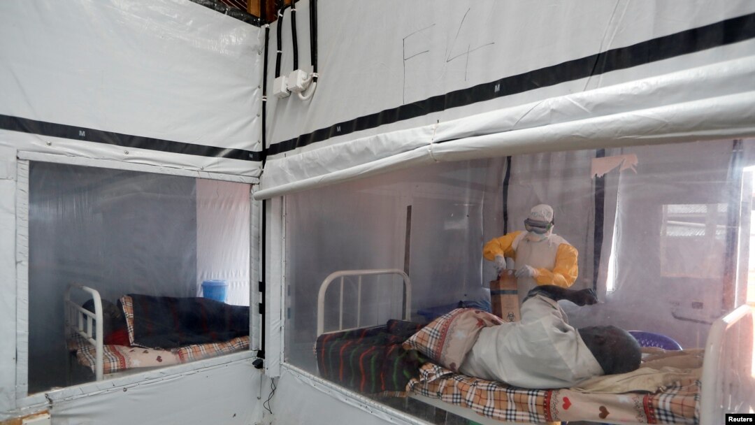 FILE - Moise Vaghemi, an Ebola survivor who works as a nurse, tends to a suspected Ebola sufferer inside the Biosecure Emergency Care Unit at an Ebola treatment center in Katwa, DRC, Oct. 3, 2019.