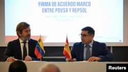 El ministro de Petróleo de Venezuela, Pedro Tellechea (dr.), y Francisco Gea, director general ejecutivo de Exploración y Producción de Repsol, firman un acuerdo para reactivar su producción de crudo y gas, en Caracas, Venezuela, el 18 de diciembre de 2023.