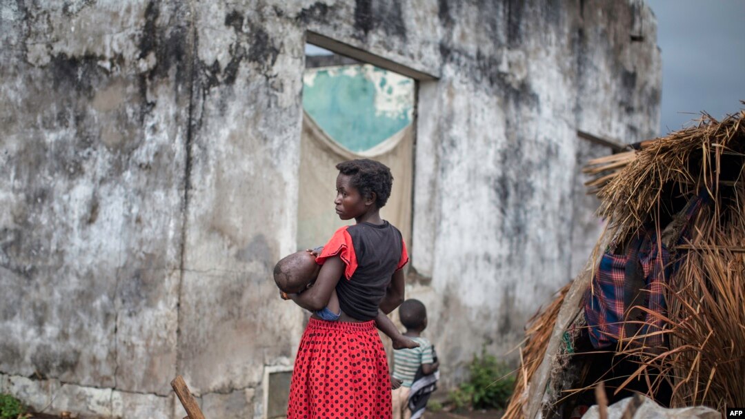 FILE - A woman holds her child at a makeshift camp for internally displaced persons (IDPs) among old abandoned buildings in Kalemie, Tanganyika province, Democratic Republic of the Congo, Sept. 18, 2017.