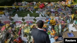 FILE - A man prays at a makeshift memorial outside the Tree of Life synagogue following the Oct. 27, 2018, shooting at the house of worship in Pittsburgh, Pennsylvania, Oct. 31, 2018. 