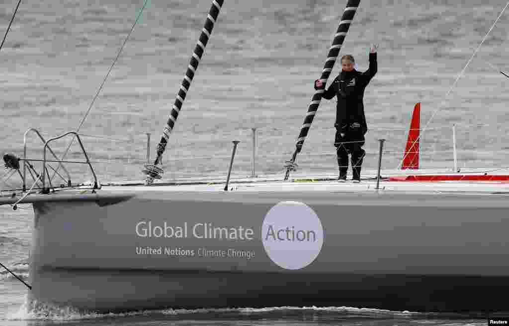 Swedish teenage climate activist Greta Thunberg waves from a boat as she starts her trip to New York, in Plymouth, Britain.