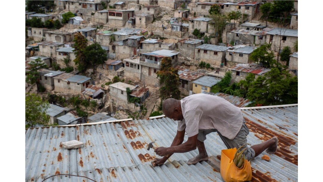 A man secures the roof of his house in preparation for Tropical Storm Elsa, in Port-au-Prince, Haiti, July 3, 2021.