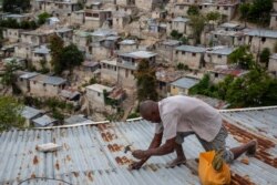 A man secures the roof of his house in preparation for Tropical Storm Elsa, in Port-au-Prince, Haiti, July 3, 2021.