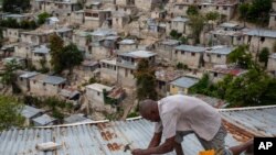 Antony Exilien secures the roof of his house in response to Tropical Storm Elsa, in Port-au-Prince, Haiti, July 3, 2021.