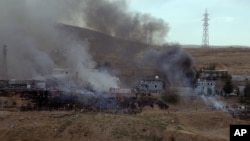 Smoke rises and fires still burn after Kurdish militants attacked a police checkpoint in Cizre, southeast Turkey, Aug. 26, 2016, with an explosives-laden truck, killing several police officers and wounding dozens more.