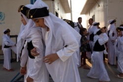 In this Sept. 14, 2019 photo, Yazidi youth, dressed in traditional clothes, take part in a program to reacquaint them with their religion and culture at Khanke IDP Camp, northern Iraq.