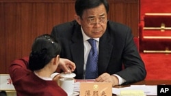 A Ukrainian soldier stands behind a fence while unidentified armed men block the headquarters of the Ukrainian Navy in Sevastopol.