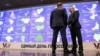Двоє чоловіків перед інформаційним екраном в Центральній виборчій комісії в Москві, 8 вересня 2023 року. (Photo by AFP)