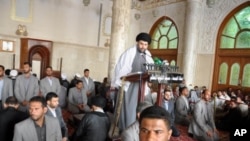 In this Friday, May 13, 2011, file photo, radical Shiite cleric Muqtada al-Sadr is surrounded by bodyguards as he speaks at Friday prayers in Kufa, 160 kilometers (100 miles) south of Baghdad, Iraq.