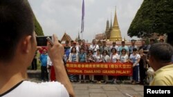 Turis China berfoto ketika berkunjung ke Wat Phra Kaeo (Emerald Buddha Temple) di Bangkok 23 Maret 2015. Kemarahan publik memaksa pemerintah Thailand mengeluarkan aturan etiket bagi turis asing.