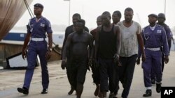 FILE - In this Feb. 22, 2016, photo, Nigeria naval officers escort arrested pirates that hijacked the Panama-flagged Maximus vessel.