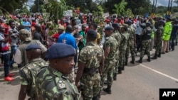 FILE - Demonstrators in Malawi rally in an anti-government protest as members of the country's security forces look on, in Lilongwe, Malawi, April 27, 2018. With elections nearing, pressure on rights activists is said to have increased in the country.