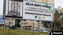 A man walks past a billboard that describe the former Brazilian President Luiz Inacio Lula da Silva in a jail, one week before his testimony to the federal judge Sergio Moro, in Curitiba, Brazil, May 5, 2017. Sign reads "Welcome! The republic of Curitiba awaits you with open jail." 