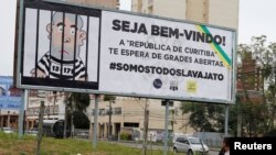 FILE - A man walks past a billboard that describes the former Brazilian President Luiz Inacio Lula da Silva in a jail, in Curitiba, Brazil, May 5, 2017. 
