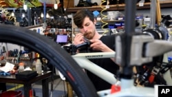 Thomas Strater, yang bekerja sebagai mekanik, sedang merakit sepeda di University Bicycles di Boulder, Colorado, 30 April 2024. Departemen Perdagangan melaporkan, Kamis, 26 September 2024, bahwa ekonomi AS tumbuh lebih tinggi dari perkiraan. (Thomas Peipert/AP Photo)