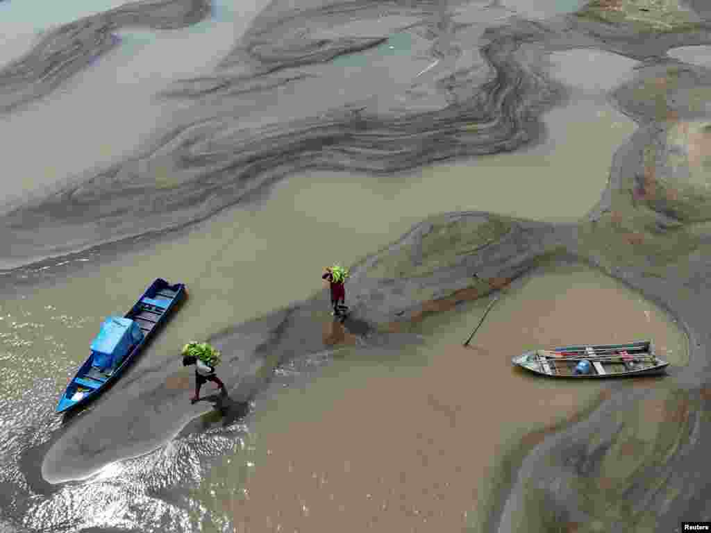 A drone view shows people carrying bananas walking over sandbanks due to the drought affecting the Solimoes River in Manacapuru, Amazonas state, Brazil, Sept. 14, 2024. 