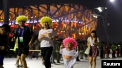 Una familia china camina por el "Nido de aves", como se conoce al estadio Olímpico de Beijing. La ciudad fue escogida como sede de las Olimpiadas de Invierno de 2022.