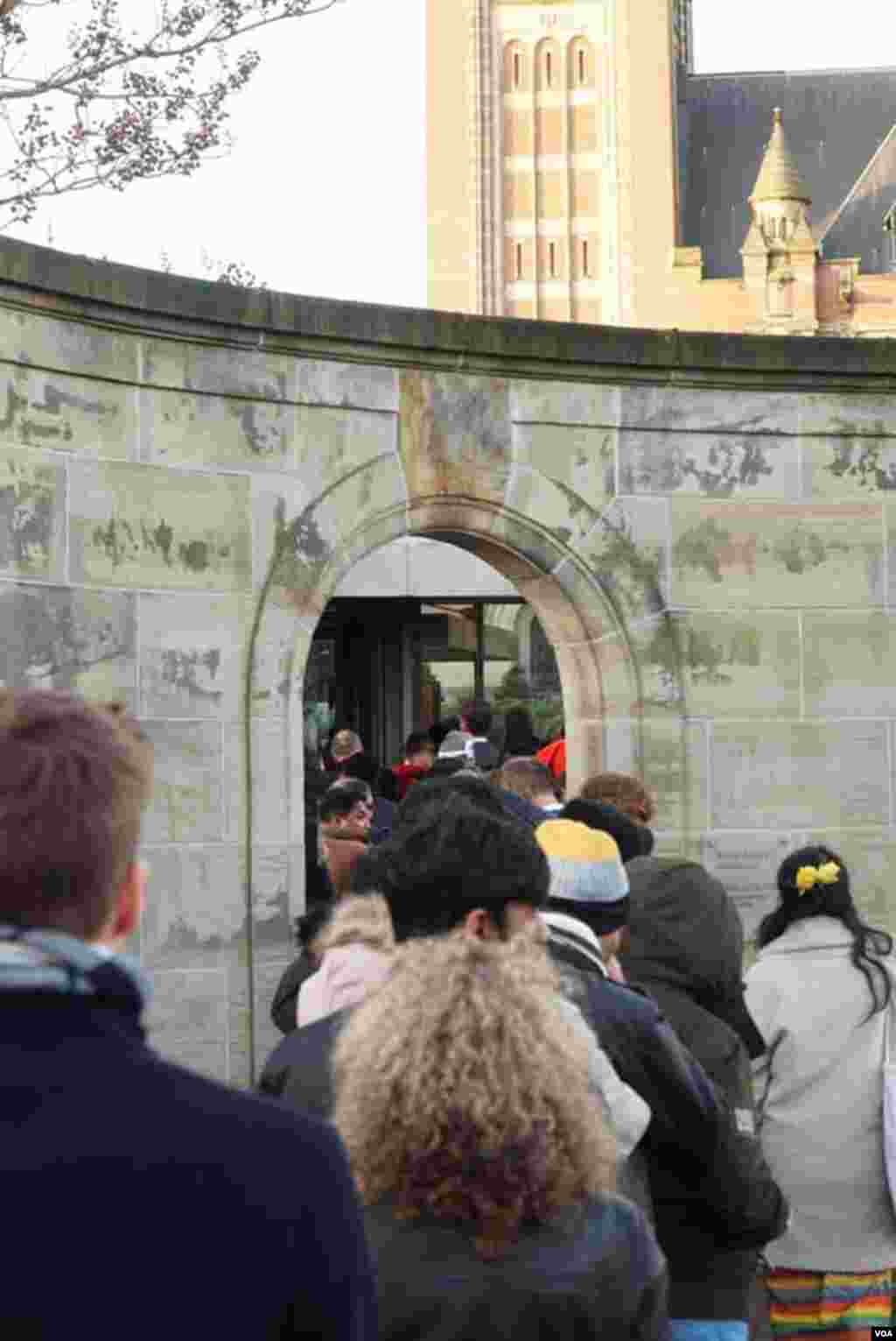 Journalists and members of the public queu