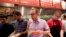 FILE - Steve Ells, center, CEO of Chipotle Mexican Grill, eats a burrito at a New York Chipotle restaurant. The chain's loaded chicken burrito contains 2,790 mg of sodium.