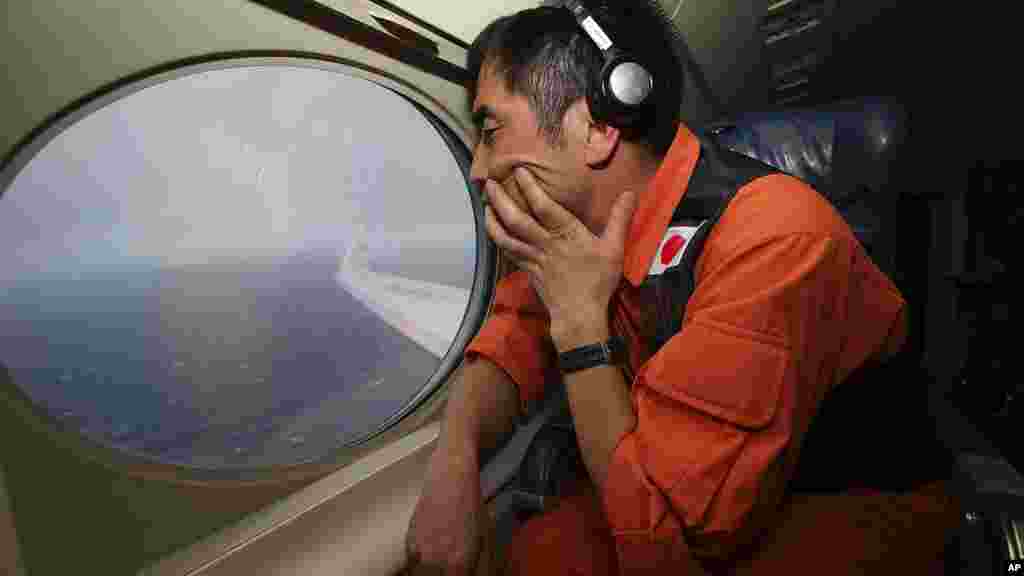 Koji Kubota of the Japan Coast Guard keeps watch while flying in the search zone for debris from Flight MH370, April 1, 2014.