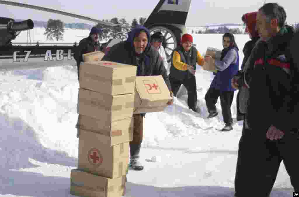 Bosnian people carrying food supplies in a remote village, cut of by road due high snow fall, near Bosnian town of Sokolac, 70 kms east of Sarajevo, Bosnia, on February 1, 2012. (AP)