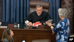 FILE - Supreme Court Chief Justice John Roberts reads the results of the vote on approving rules of impeachment, Jan. 22, 2020.