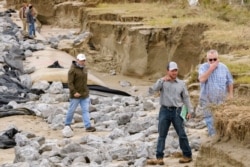 Members of the U.S. Army Corps of Engineers survey levee damage along Grand Isle, La., Oct. 30, 2020. Gov. John Bel Edwards says the damage from Hurricane Zeta was “catastrophic” in Grand Isle, a barrier island community south of New Orleans.