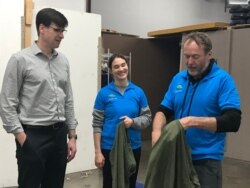 GJS instructors Shane Bell, right, and Camille Lake demonstrate how to make a stretcher out of t-shirts. (Daphne Dung-Ning Fan/VOA)