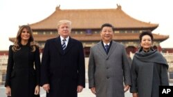 President Donald Trump, second left, first lady Melania Trump, left, Chinese President Xi Jinping, second right, and his wife Peng Liyuan, right, stand together as they tour the Forbidden City, Nov. 8, 2017, in Beijing, China. 