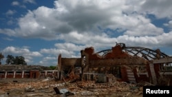 30일 우크라이나 하르키우 외곽 말라 다닐리브카에서 러시아의 미사일 공격으로 소방관들이 피해를 입은 학교 피해 복구 작업을 하고 있다.