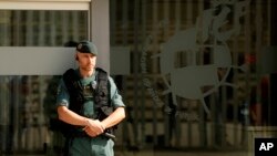 A Spanish Civil Guard policeman stands guard outside the Spanish Football Federation headquarters during an anti-corruption operation in Las Rozas, outside Madrid, July 18, 2017. Spanish Football Federation president Angel Maria Villar was arrested Tuesday along with his son and two more federation executives as part of an anti-corruption probe.