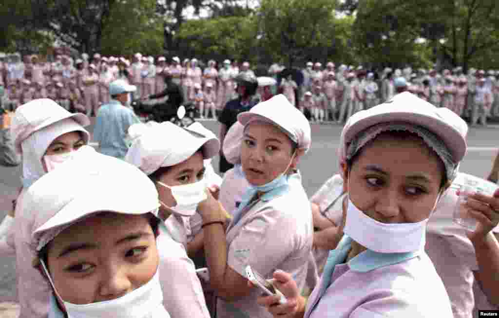 Pekerja perempuan berkumpul di depan sebuah pabrik selama demonstrasi di daerah industri Karawang, Jawa Barat.&nbsp; 