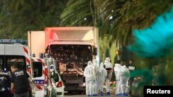 Polisi dan petugas forensik Perancis memeriksa truk yang menabrak kerumunan massa pada perayaan Hari Bastille di kota Nice, Perancis Kamis malam (14/7). 