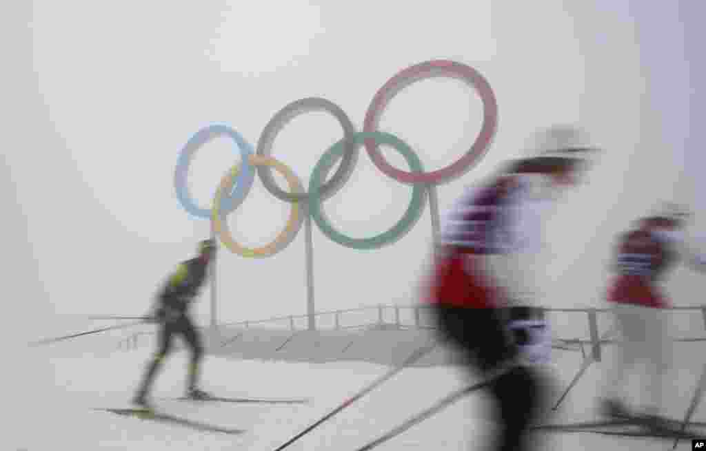 Cross-country skiers train in front of the olympic rings at the Laura biathlon and cross-country ski center, at the 2014 Winter Olympics, Feb. 17, 2014.