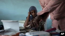 FILE - Surgeon and doctor-turned-refugee, Dr. Tewodros Tefera, prepares a malaria test for 23-year-old Tigrayan refugee Hareg from Mekele, Ethiopia, at the Sudanese Red Crescent clinic in Hamdayet, eastern Sudan, near the border with Ethiopia, on March 17, 2021. 