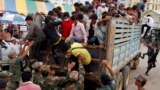 Cambodian migrant workers get off from a Thai truck upon their arrival from Thailand at a Cambodia-Thai international border gate in Poipet, Cambodia, Tuesday, June 17, 2014. 