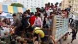 FILE: Cambodian migrant workers get off from a Thai truck upon their arrival from Thailand at a Cambodia-Thai international border gate in Poipet, Cambodia, Tuesday, June 17, 2014. (AP Photo/Heng Sinith)