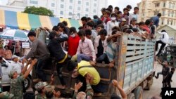 FILE: Cambodian migrant workers get off from a Thai truck upon their arrival from Thailand at a Cambodia-Thai international border gate in Poipet, Cambodia, Tuesday, June 17, 2014. (AP Photo/Heng Sinith)