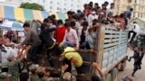 Cambodian migrant workers get off from a Thai truck upon their arrival from Thailand at a Cambodia-Thai international border gate in Poipet, Cambodia, Tuesday, June 17, 2014. The number of Cambodians who have returned home from Thailand this month after a