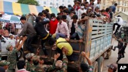 Cambodian migrant workers get off from a Thai truck upon their arrival from Thailand at a Cambodia-Thai international border gate in Poipet, Cambodia, Tuesday, June 17, 2014. 