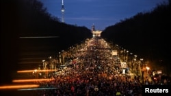 People march during a protest against the migration plans of the CDU party leader and top candidate for Chancellor Friedrich Merz and the far-right Alternative for Germany party (AfD), in Berlin, Germany, Feb. 2, 2025. 